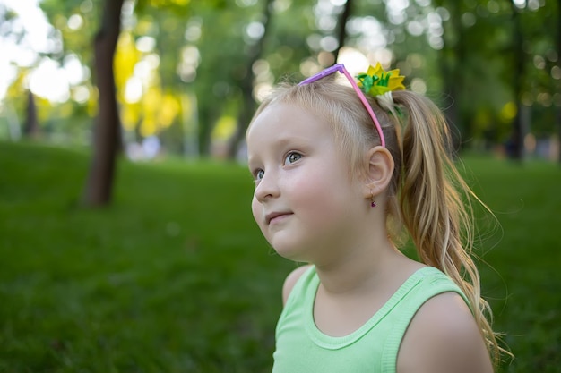 Portrait d'une petite fille modèle qui pose pour la caméra dans le parc