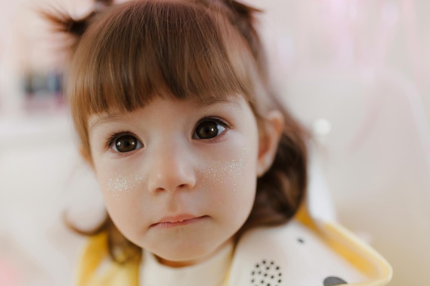 Portrait d'une petite fille avec des paillettes sur son visage portrait d'enfant