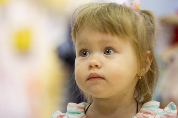 Portrait de la petite fille parmi les jouets en magasin pour enfants, téléobjectif