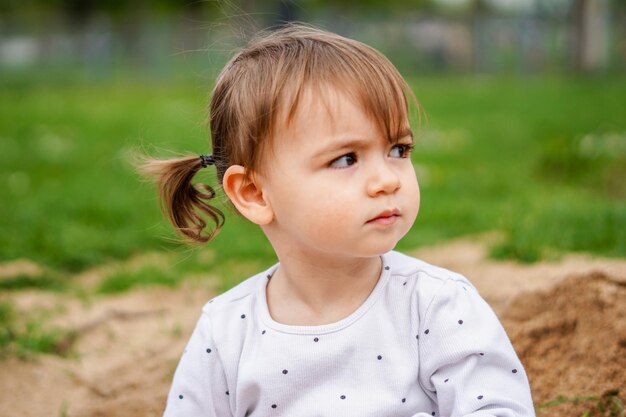 Portrait de petite fille Pigtail petite fille gros plan Kid dans la nature en se concentrant sur le visage