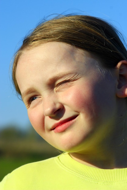 portrait d'une petite fille qui plisse les yeux avec un joli visage