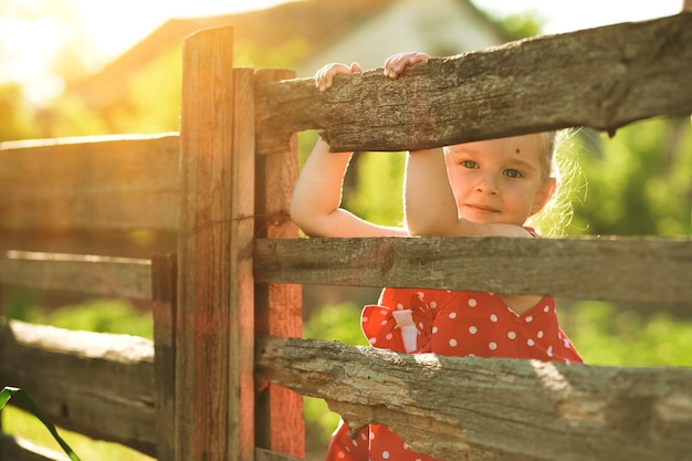 portrait de petite fille regardant la caméra près de la balustrade en bois