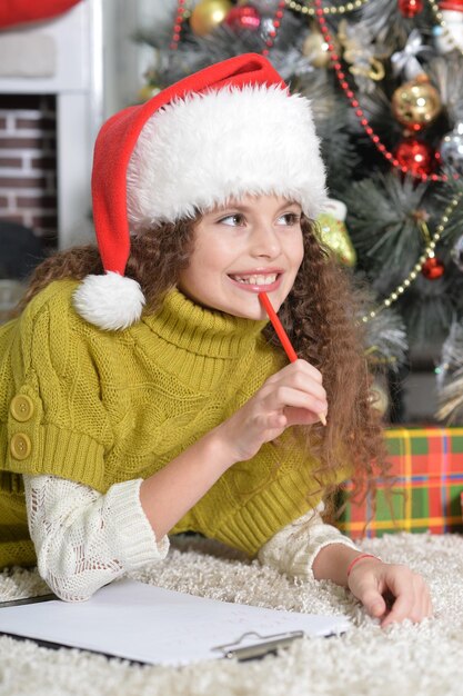 Portrait de petite fille souriante écrivant une lettre