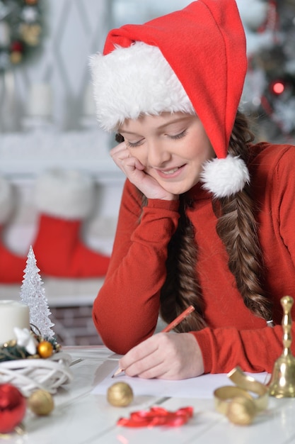 Portrait de petite fille souriante écrivant une lettre