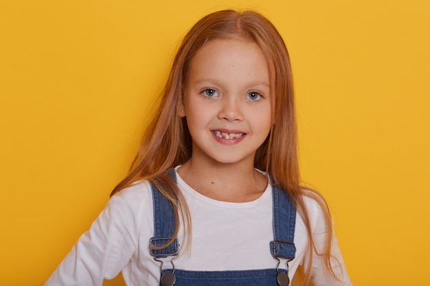 Portrait de petite fille souriante. Studio photo isolé sur jaune