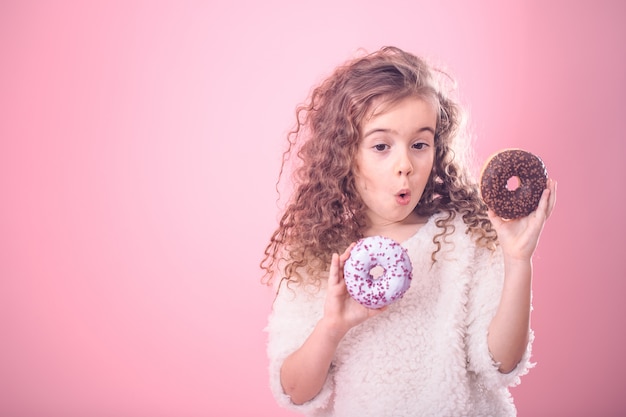 Portrait d'une petite fille surprise avec des beignets