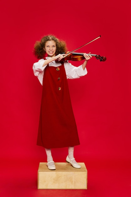 Portrait d'une petite fille talentueuse musicienne portant d'énormes mères robe d'été jouant du violon s'amusant