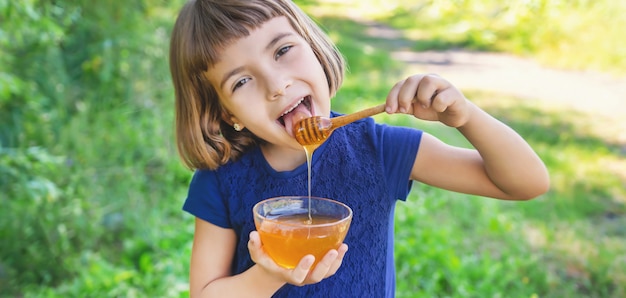 Portrait d'une petite fille tenant un bol de miel