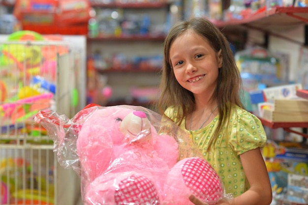 Portrait de petite fille tenant un ours en peluche rose