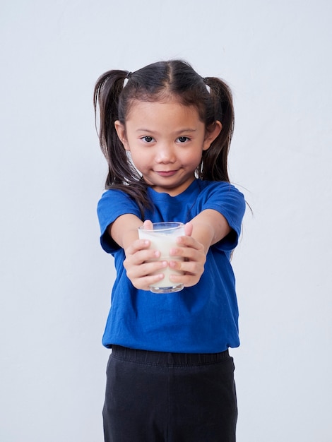 Portrait de petite fille avec un verre de lait sur la lumière