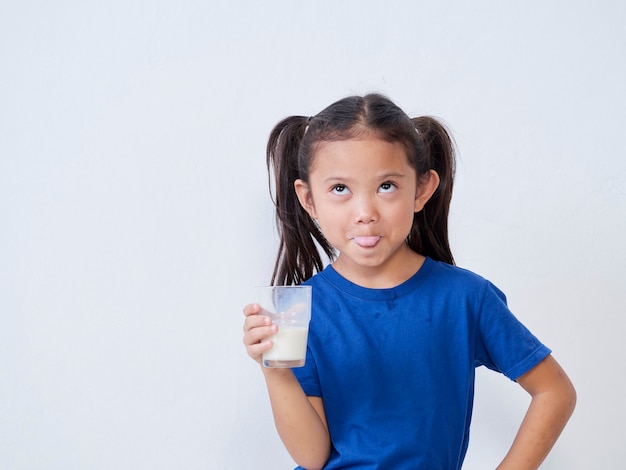 Portrait de petite fille avec un verre de lait sur la lumière