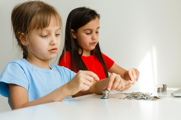 portrait de petites filles assises à table et calculant de l'argent