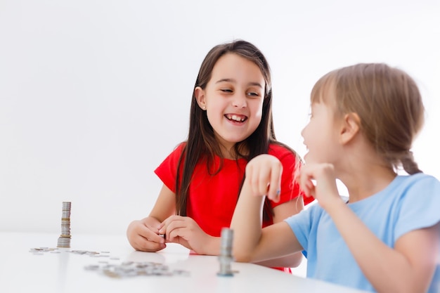 portrait de petites filles assises à table et calculant de l'argent