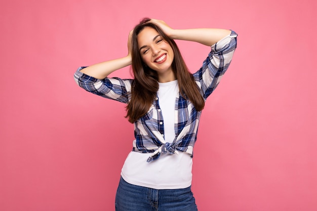 Portrait photo de la belle jeune femme brune hipster souriante en chemise bleue et blanche à la mode et