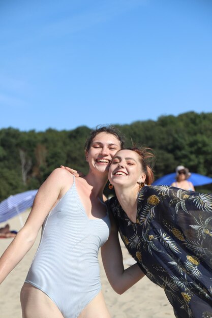 Portrait photo de deux amies souriant sur la plage