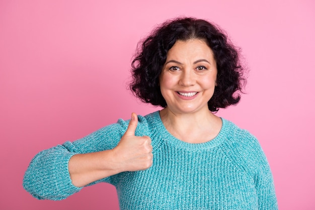 Portrait photo d'une femme âgée montrant un geste du pouce vers le haut souriant fond de couleur pastel isolé