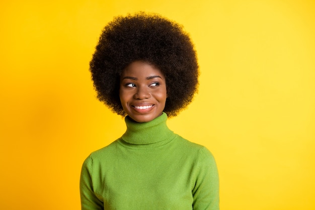 Portrait photo d'une fille afro-américaine regardant à côté de penser à rêver isolé sur fond de couleur jaune vif