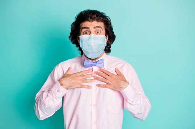 Portrait photo d'un homme touchant la poitrine portant un respirateur médical isolé sur fond de couleur sarcelle pastel