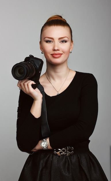 Portrait d'un photographe jeune belle fille avec son appareil photo. Photographie de studio. SÉANCE PHOTO