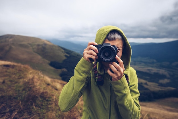 Portrait de photographe de voyage avec appareil photo dans les montagnes