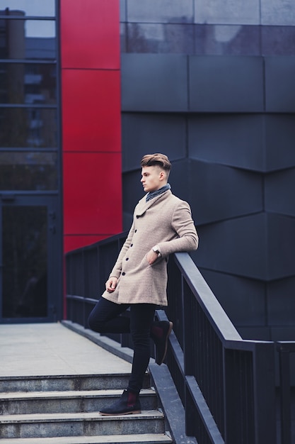 Portrait en pied d'un homme élégant dans un manteau dans la ville