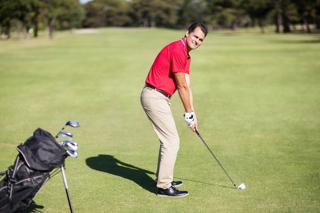 Portrait en pied d'un homme jouant au golf