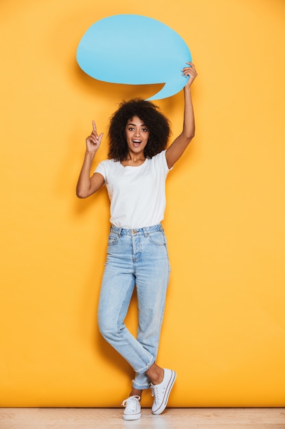 Portrait en pied d'une jeune femme africaine excitée