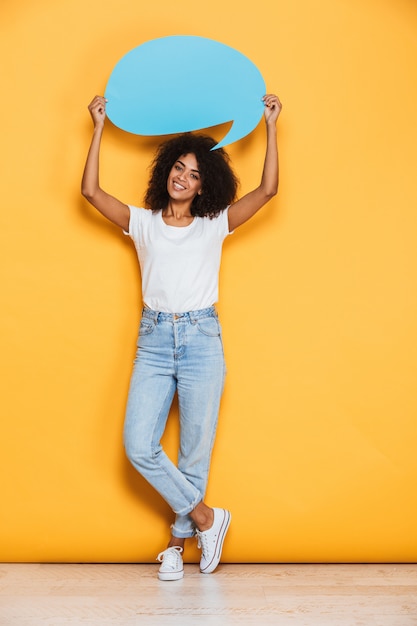 Portrait en pied d'une jeune femme africaine heureuse