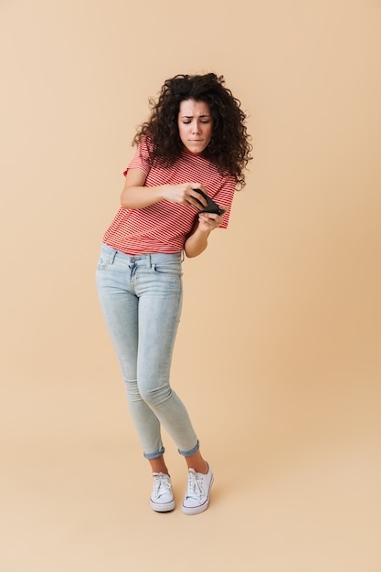 Portrait en pied d'une jolie jeune femme jouant à des jeux