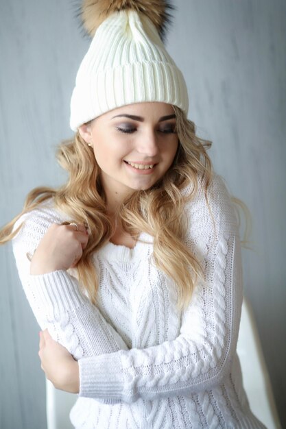 Portrait de plan rapproché d'une femme dans un chapeau blanc et un pull en laine blanc