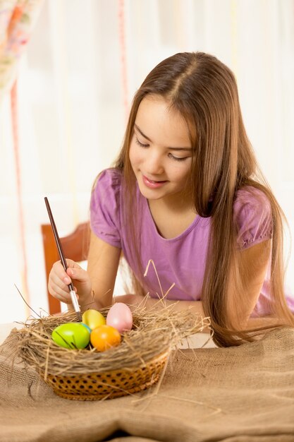 Portrait de plan rapproché de fille de sourire mignonne préparant des oeufs de pâques