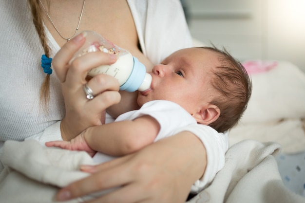 Portrait de plan rapproché de mère nourrissant le bébé nouveau-né de la bouteille