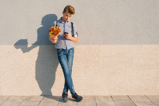 Portrait en plein air d'adolescent avec bouquet de fleurs