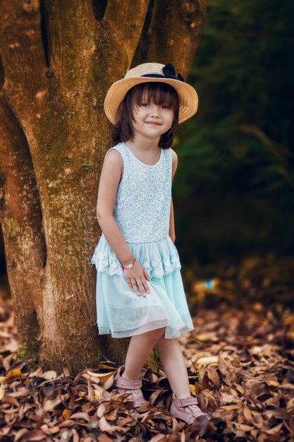 Portrait en plein air de l'adorable petite fille vêtue d'une robe blanche.