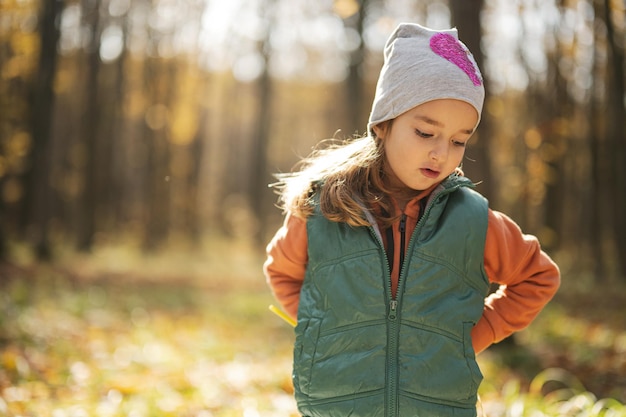Portrait en plein air d'automne d'une belle fille enfant heureuse dans la forêt