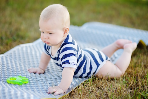 Portrait en plein air d&#39;un bébé de six mois joue avec un jouet brillant