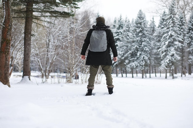 Portrait en plein air de bel homme en manteau et scurf. Homme barbu dans les bois d'hiver.