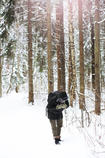 Portrait en plein air de bel homme en manteau et scurf. Homme barbu dans les bois d'hiver.