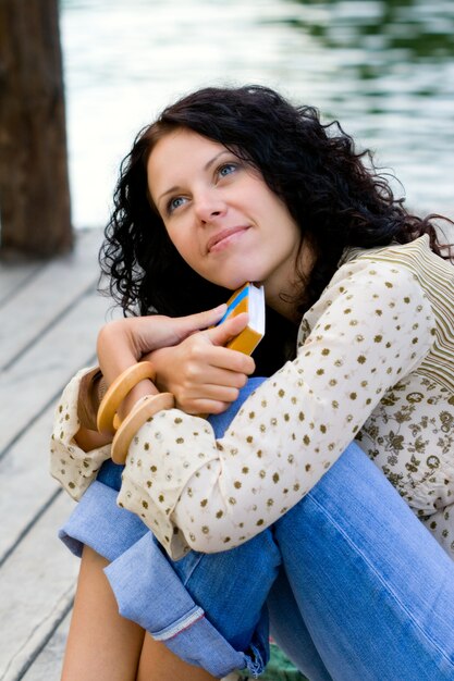 Portrait en plein air d&#39;une belle femme avec un livre