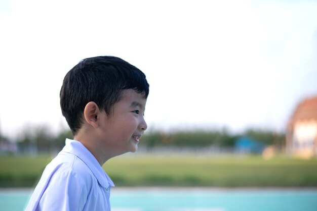 Portrait en plein air d'un enfant étudiant asiatique heureux