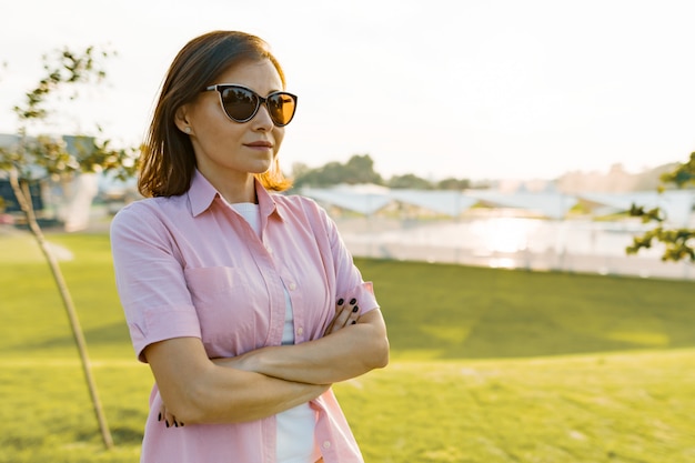 Portrait en plein air d'une femme mature avec les bras croisés