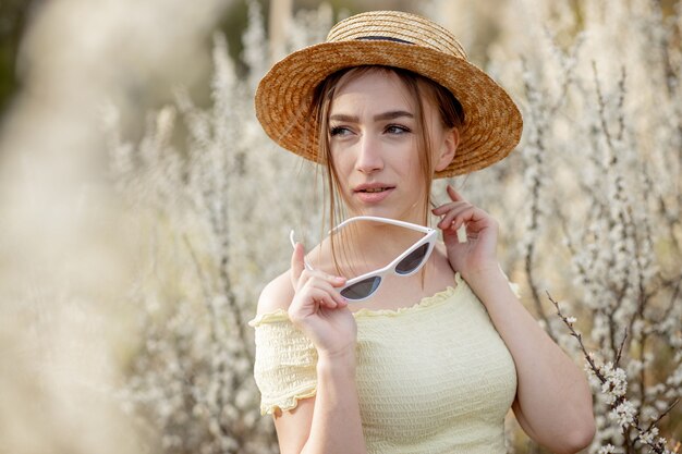 Portrait en plein air de fille de mode de printemps en fleur. Beauté femme romantique en fleurs. Belle femme appréciant la nature.