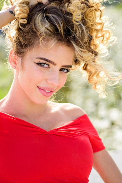 Portrait en plein air de jeune belle fille souriante heureuse vêtue d'une robe rouge mode printemps été