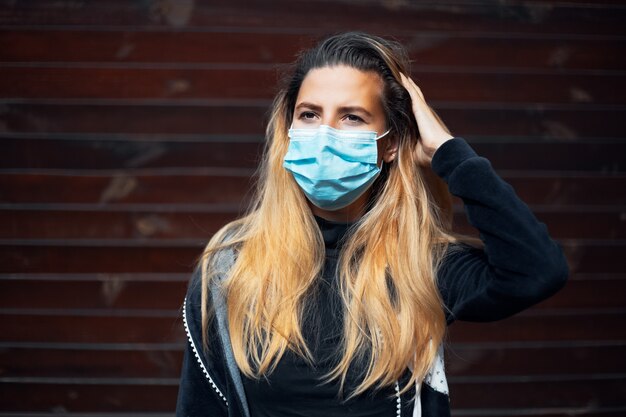 Portrait en plein air de jeune fille portant un masque de grippe médicale sur le visage contre le coronavirus