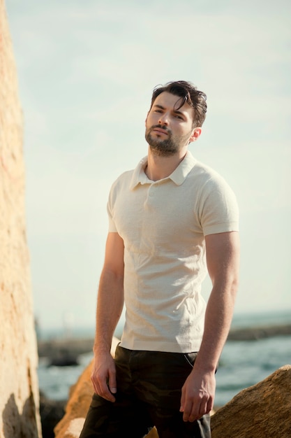 Portrait en plein air de jeune homme élégant, polo blanc