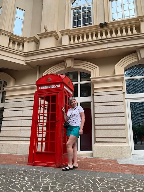 Photo portrait en pleine longueur d'une femme debout près d'une cabine téléphonique