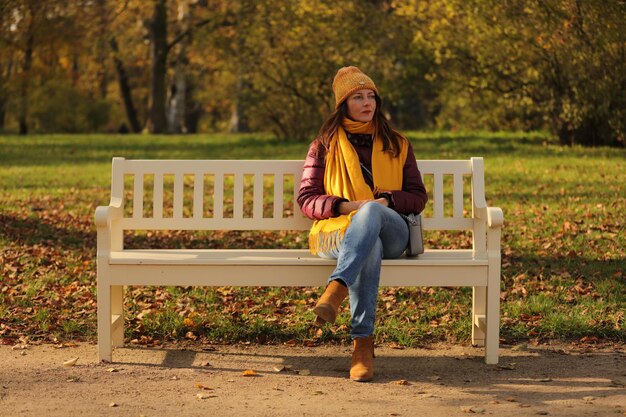 Photo portrait en pleine longueur d'une jeune femme assise sur un banc