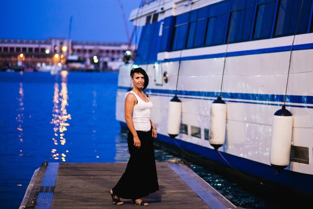 Photo portrait en pleine longueur d'une jeune femme debout au port