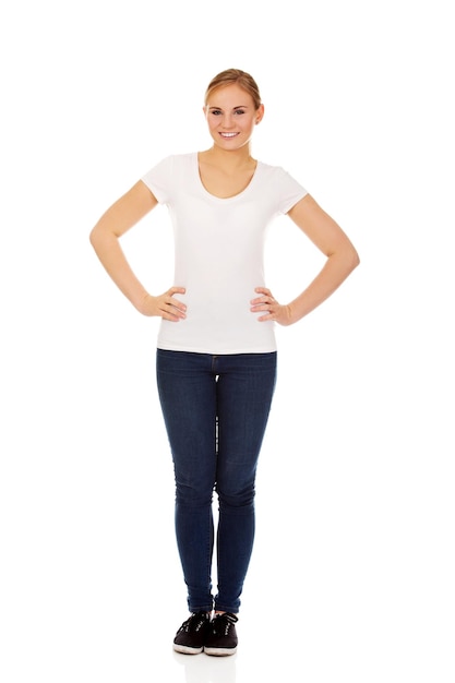 Portrait en pleine longueur d'une jeune femme souriante debout sur un fond blanc