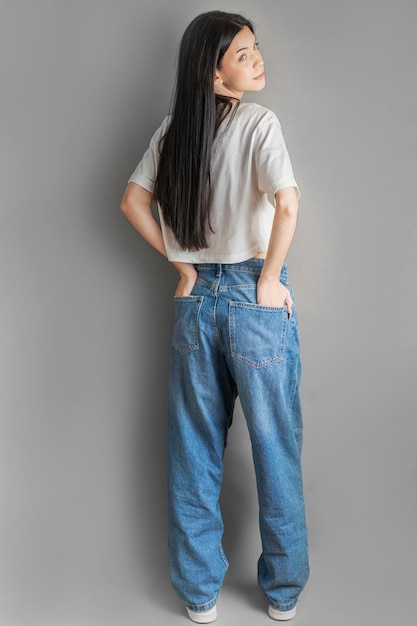 Portrait en pleine longueur d'une jeune fille en chemise blanche et en jean